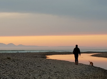 person walking dog on the beach Machrihanish Holiday park