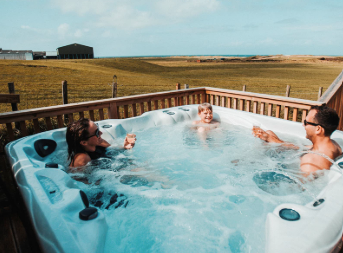 family sitting in hot tub overlooking Machrihanish Holiday Park